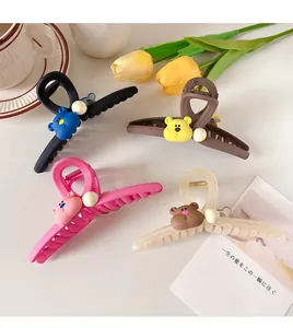 Detail view of colorful bear claw clips with white pearl accents and metal springs