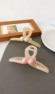 Detail view of pink and yellow resin hair claws with dimensions 13cm x 6cm and specifications