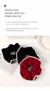 Detail view of velvet hair scrunchies with white faux pearls in black and retro red colors