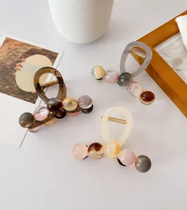 Detail view of 8.5cm large resin hair claw clips in amber and grey with bead design