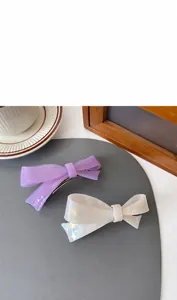 Detail of 11cm acetate bow hair claw clip showing size and dual-color glossy texture