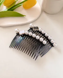 Detailed view of hair combs with faux pearls and clover charms on a black base