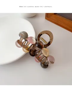 Detailed macro view of amber resin hair claw clip with colorful decorative beads