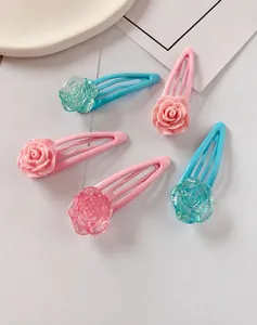 Detailed macro shot of five resin rose flower hair clips in pink and blue pastel colors