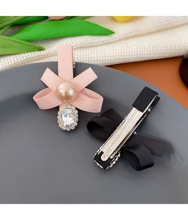 Detail von rosa und schwarzen Schleifen-Haarspangen mit Perlen und Strass auf Entenschnabelclip