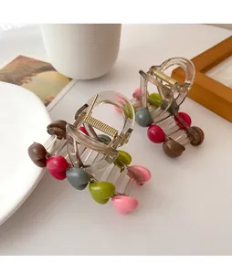 Detail of transparent hair claws featuring colorful 3D resin hearts and golden spring