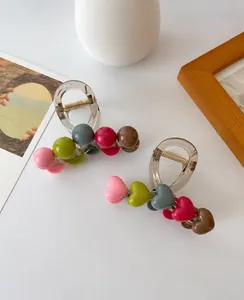 Detailed view of colorful heart-shaped beads on a clear acrylic hair claw clip