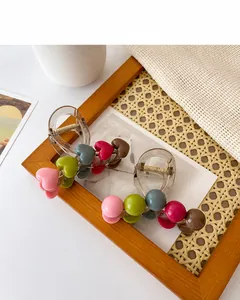 Detail of two resin hair claws with colorful hearts on wooden frame background