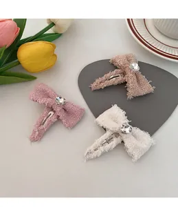 Detail of tweed bow hair clips with heart crystal center and frayed edges set of three