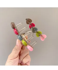 Detail of transparent hair claw clip with colorful heart shapes and metal spring