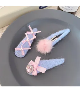 Close-up of three Korean-style light blue knit hair clips with pink bows and pearls