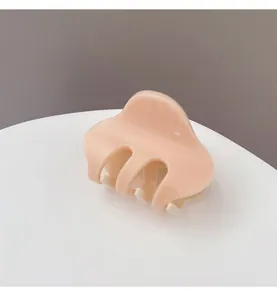 Detailed view of a sleek two-tone hair claw clip with a glossy finish and minimalist design