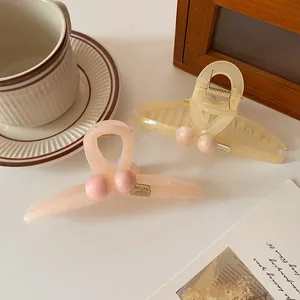 Elegant translucent resin hair claws in pink and beige with gold decorative metal plates