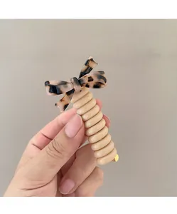 Detailansicht der Spiral-Haargummi mit brauner Schildpatt-Schleife und Metallclip