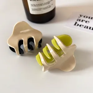 Minimalist two-tone claw clips in beige and neon green for elegant hair styling