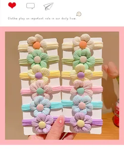 Detail of 6-piece flower hair tie set with elastic bands in pastel colors for girls