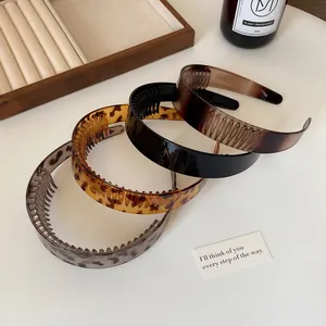 Set of four leopard and tortoiseshell non-slip hairbands with teeth on white desk