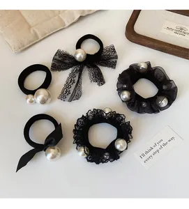 Detail of 5-piece black hair scrunchies set featuring pearls, lace, and bow designs
