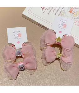 Detail of pink organza bow hair clips with heart and star rhinestones for girls
