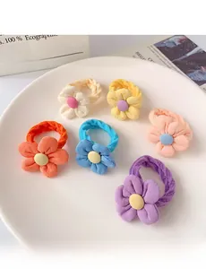 Close-up of 6 colorful floral fabric hair ties for girls on a white display plate