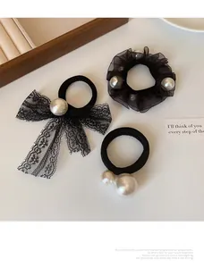 Detailed set of black elastic hair bands with pearls and lace mesh on a white table