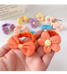 Close-up of soft cotton flower and bow elastic hair ties for girls in bright orange