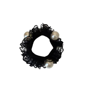 Elegant black lace hair scrunchie with three white pearls on a minimalist white background