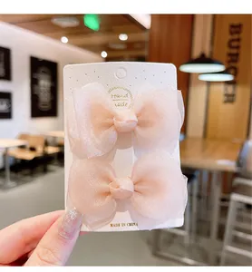 Close-up of handmade pink sheer organza bow hair clips for girls on a display card
