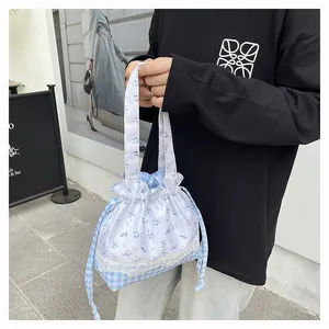 Detalle de bolsa de almuerzo con estampado floral de rejilla y ribete de encaje
