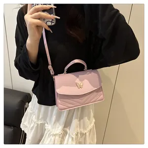 Detail der helllila Handtasche mit goldener Schmetterlingsschließe und V-Steppmuster