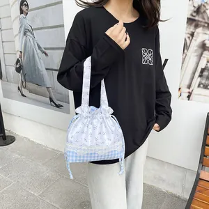 Floral and checkered drawstring lunch bag with lace detail and portable top handles