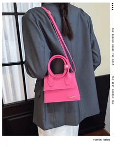 Dettaglio della mini borsa rosa con manico rotondo e tracolla regolabile