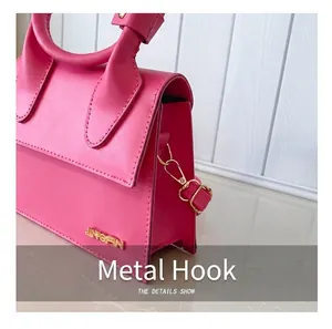 Dettaglio della borsa in pelle rosa con gancio dorato e logo in metallo