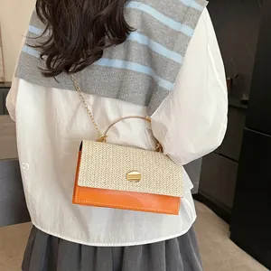Chique crossbodytas van stro en oranje leer met goudkleurig handvat en ketting