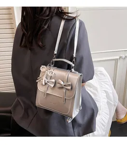 Détail du mini sac à dos argenté métallisé avec nœuds et pendentif en perles