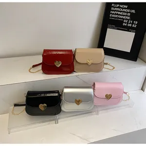 Detailed close-up of heart-shaped gold buckles on multi-colored crossbody chain bags