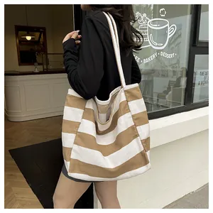 Detailaufnahme einer khakifarbenen und weiß gestreiften Canvas-Tasche mit gewebten Trägern