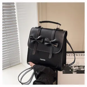 Detail shot of a black PU mini backpack featuring elegant bows and fashion lettering