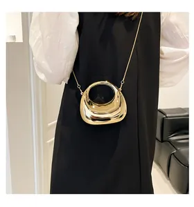 Pochette métallique dorée en forme de lune avec bandoulière chaîne sur un mannequin