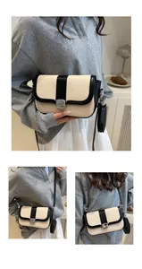 Detail of a beige woven crossbody bag with black leather trim and metal clasp