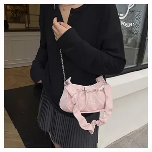Detailed shot of pink beaded handbag featuring a pleated handle and elegant pearl charm