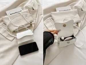 Detail view of the white patent leather handbag showing internal capacity for essentials
