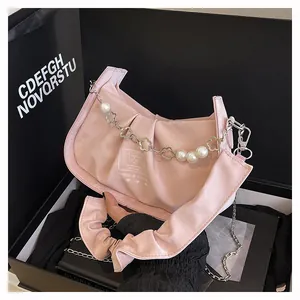 Detail of pink pleated handbag with pearl floral chain and branded white logo lettering