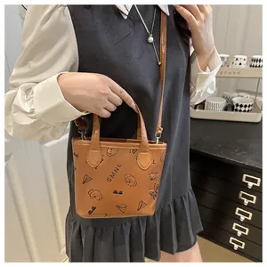 Détail du mini sac seau marron avec imprimé chiot cartoon et lettrage SMNL chic