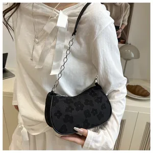 Detailed view of black crescent bag with 3D floral texture and silver chain strap