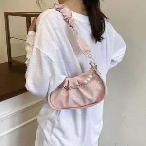 Pink pleated leather tote bag with elegant pearls and silver chain shown from side view