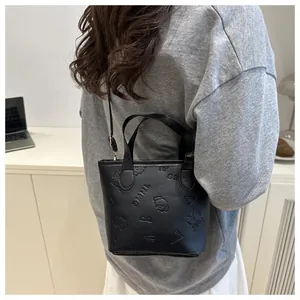 Détails du sac seau noir avec motifs papillon embossés et poignée supérieure élégante