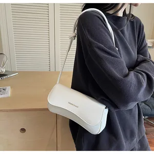 Close-up of a white rectangular flap underarm bag with gold FASHION & BAGS lettering