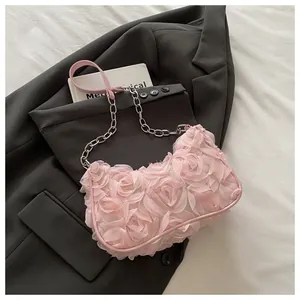 Detailed view of pink 3D rose petal evening bag on a grey blazer and white fabric