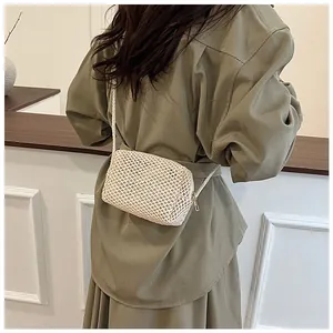 Detail van handgeweven crème crossbodytas met holle roostertextuur en ritssluiting